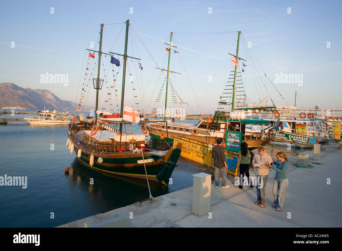 People walking on quay looking at excursion sailing boats Kardamena Kos