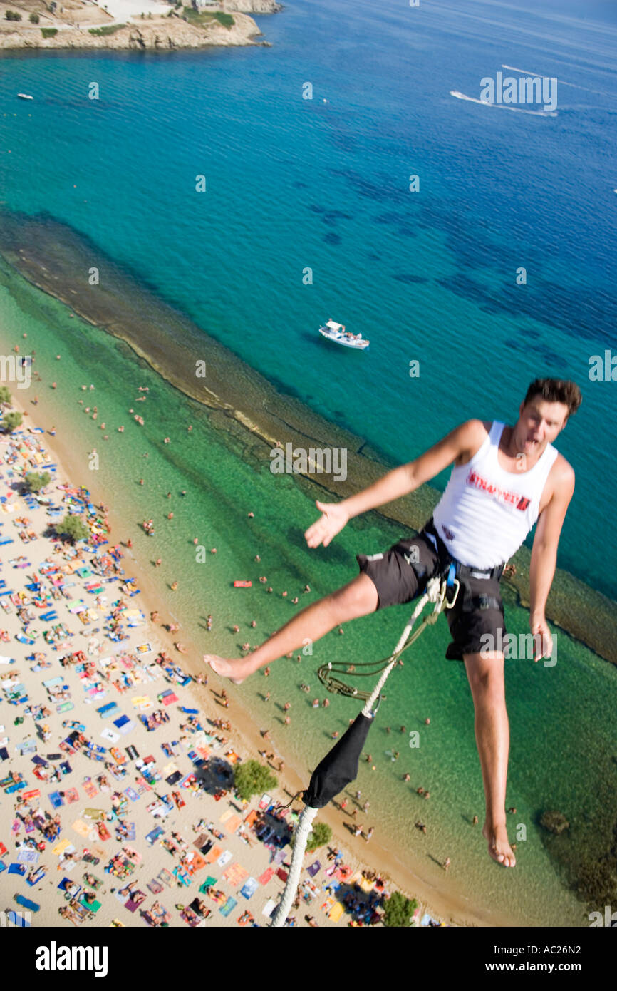 Young man bungee jumping over Paradise Beach Mykonos Greece Stock Photo