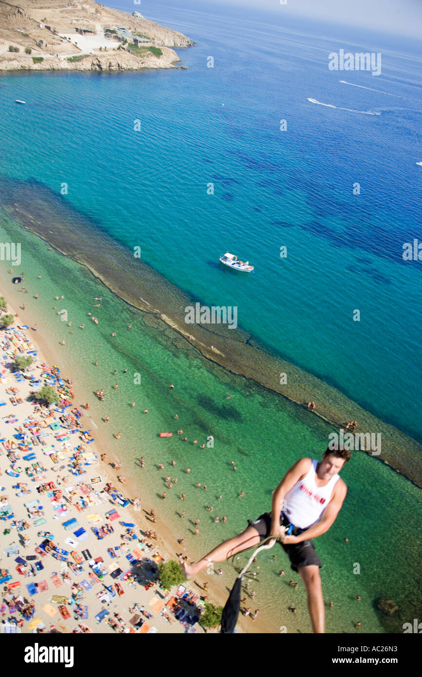 Young man bungee jumping over Paradise Beach Mykonos Greece Stock Photo