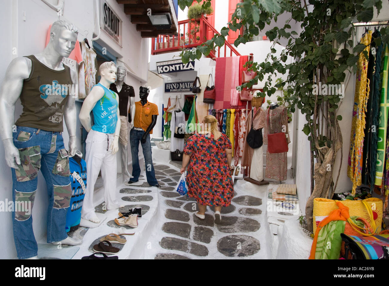 Woman passing a open clothes shop at shopping street Mykonos Town Mykonos  Greece Stock Photo - Alamy