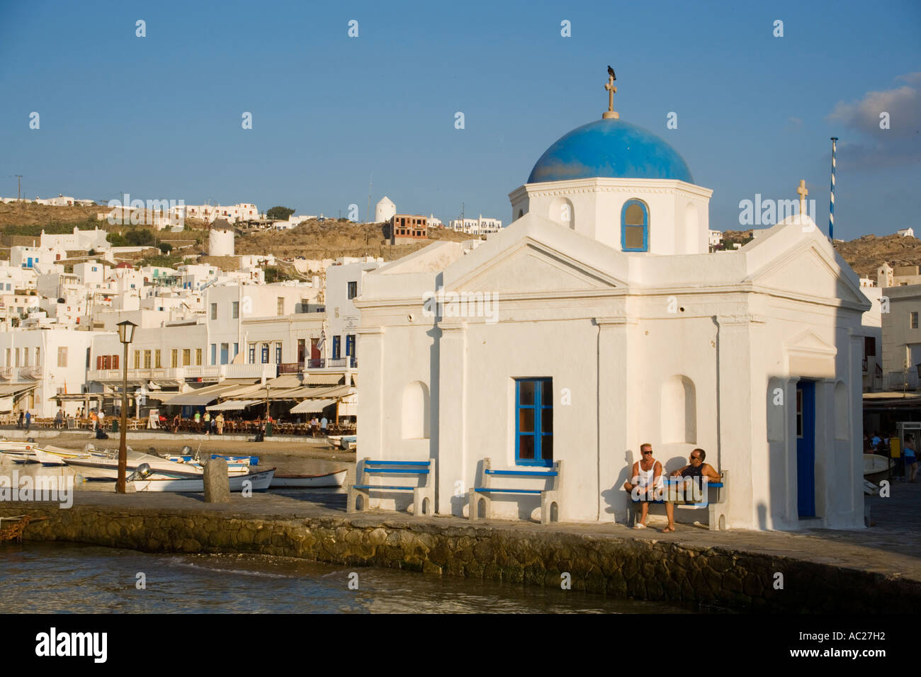 Two men sitting at a capel at harbour Mykonos Town Mykonos Greece Stock Photo