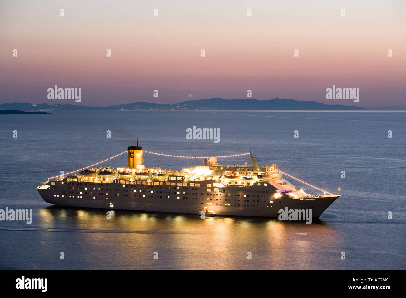 View to a illuminated crusing ship Mykonos Greece Stock Photo
