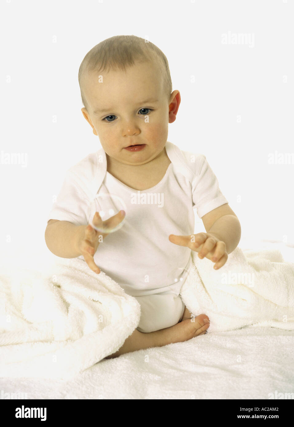 Happy baby boy seated playing with bubbles Stock Photo Alamy