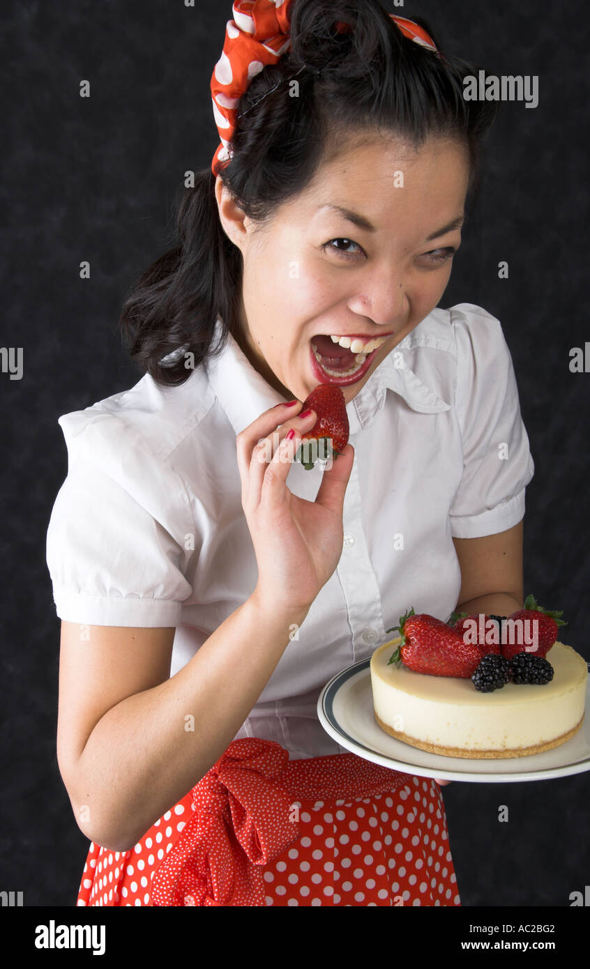 Marianne Cheesecake Chinese Girl Holding a Cheesecake Decorated with Strawberries and Blackberries on a Plate Stock Photo
