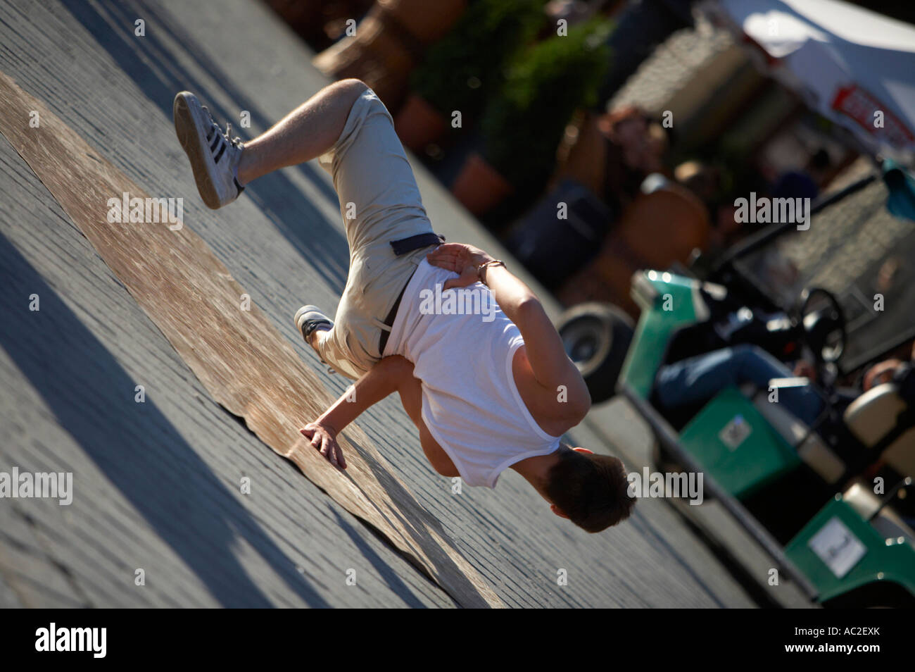 breakdancing young male street entertainer balancing on one hand in the rynek glowny main square in the old town krakow Stock Photo