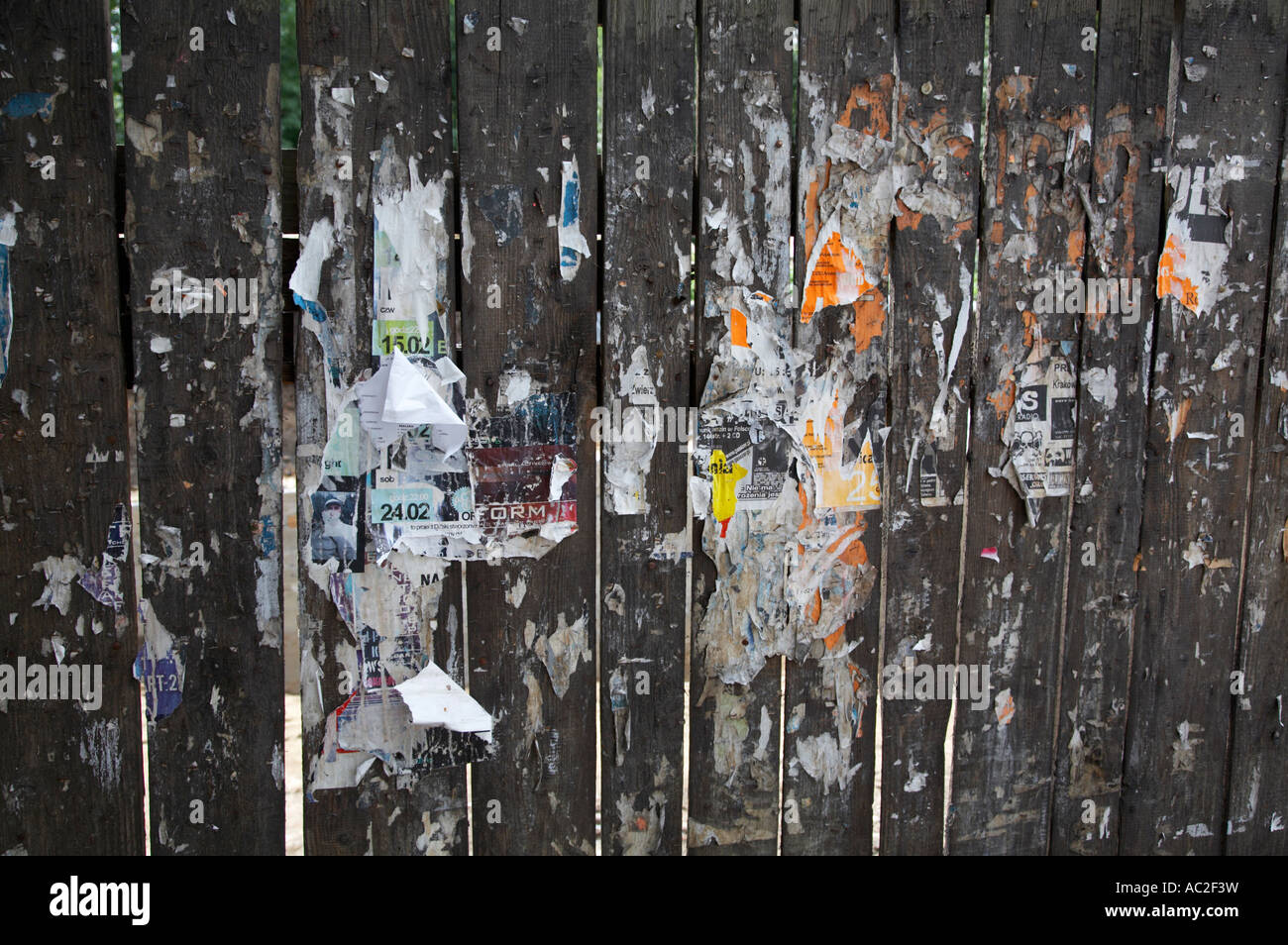 remnants of torn off fly posters on a wooden fence in kazimierz krakow Stock Photo