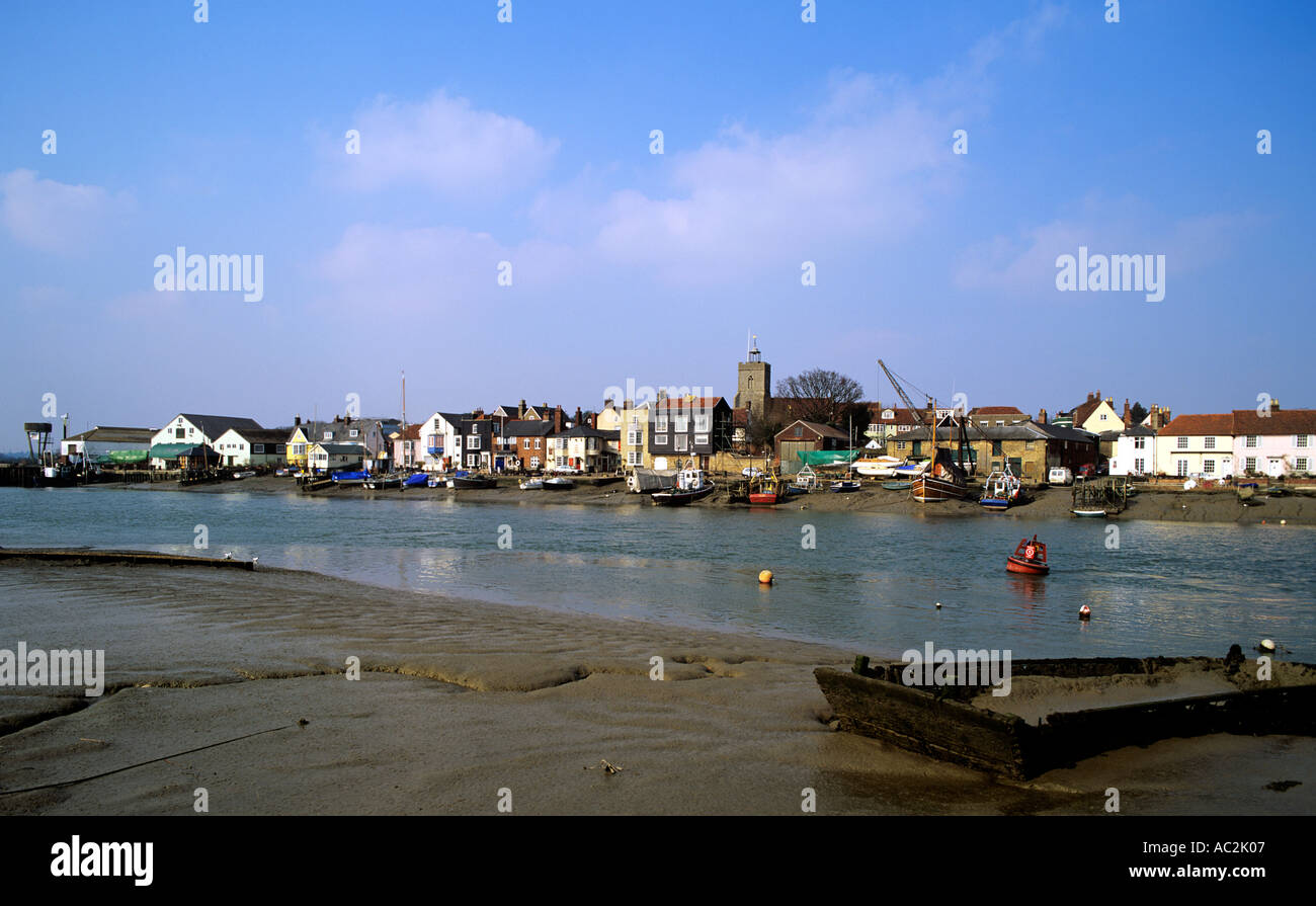 Wivenhoe River Colne flows past the fishing fleet and pleasure boats sitting on the soft mud at