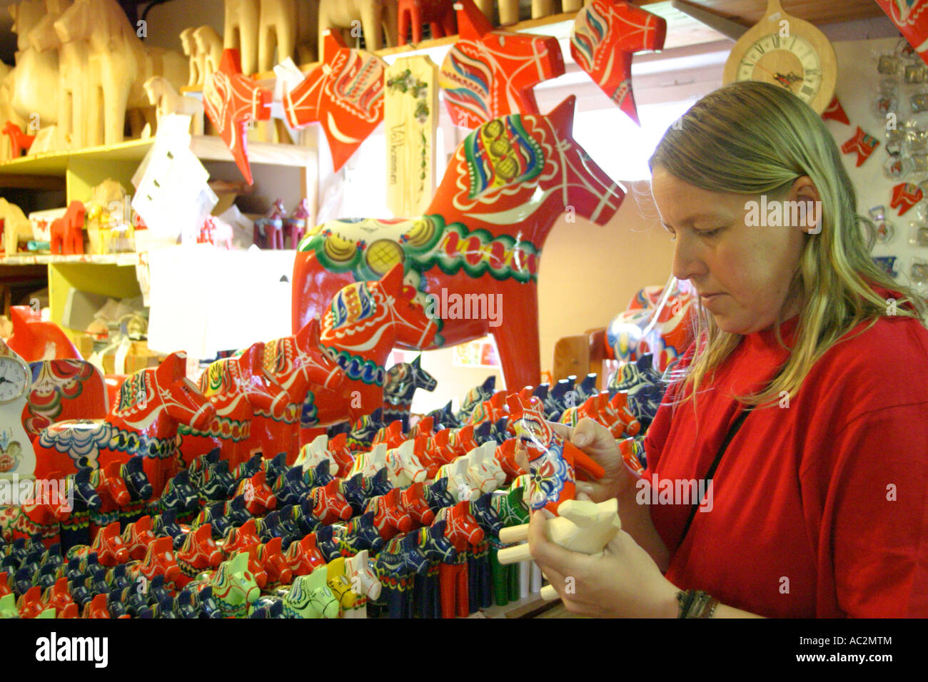 a young woman visiting a shop where Dala horses are made near Farnas in the South of Sweden Stock Photo