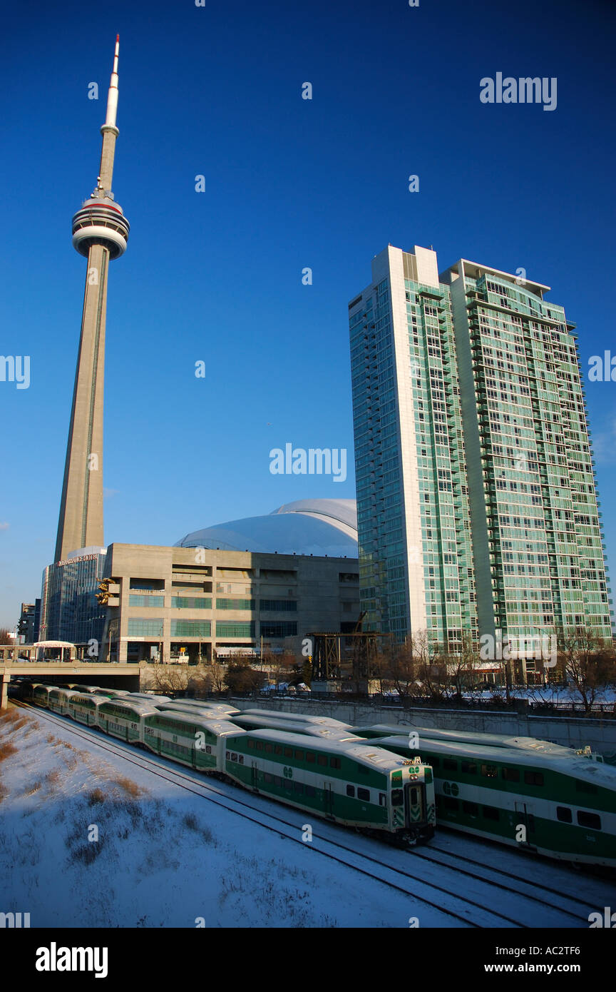 GO commuter trains leaving union station Toronto in winter with CN Tower Stock Photo