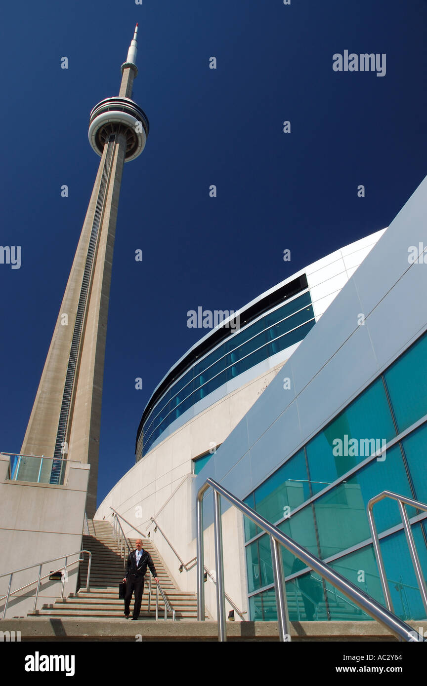Man with briefcase walking down stairs at Toronto Convention Centre with CN Tower Stock Photo