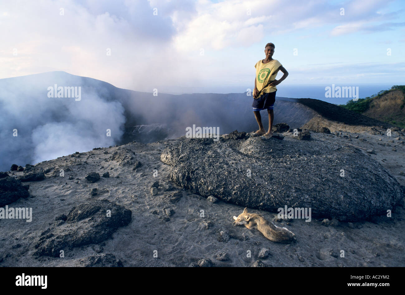 Local guide standing up on a freshly dropped lava bomb near the crater, Yasur Volcano, Sulphur Bay, Tanna, Vanuatu Stock Photo