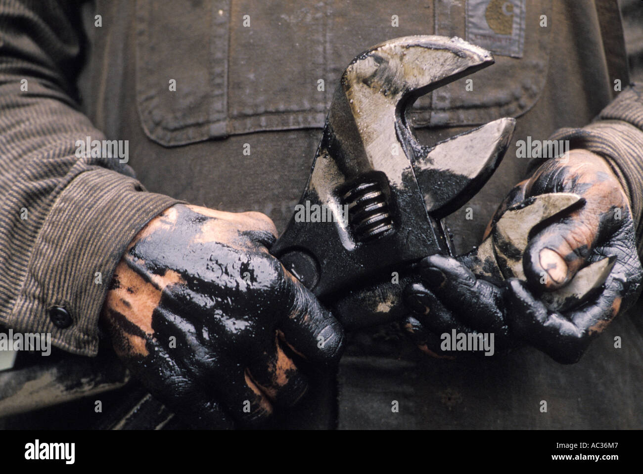 man-s-oily-hands-holding-wrenches-AC36M7.jpg