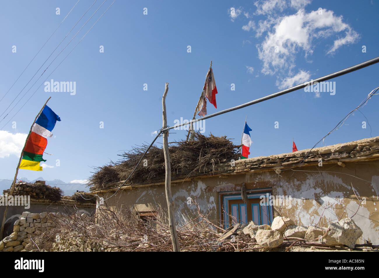 India Himachal Pradesh Spiti Nako village 2950m typical Tibetan house with prayer flags and light white cloud in blue sky Stock Photo