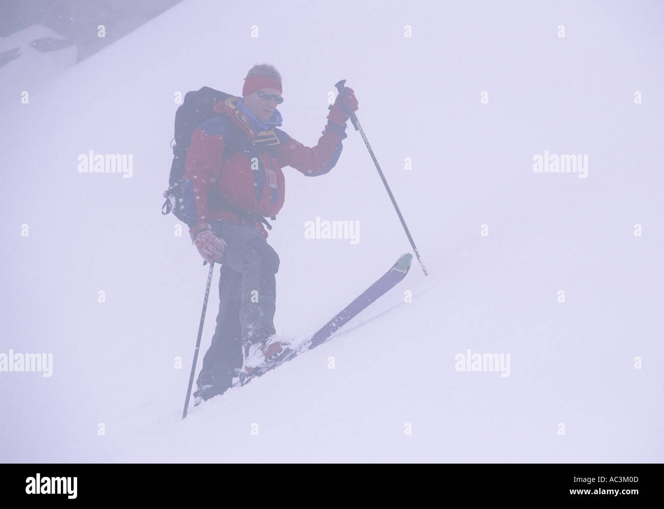 Climbing up a slope on skis in the Bedretto, Switzerland, Italy Stock Photo