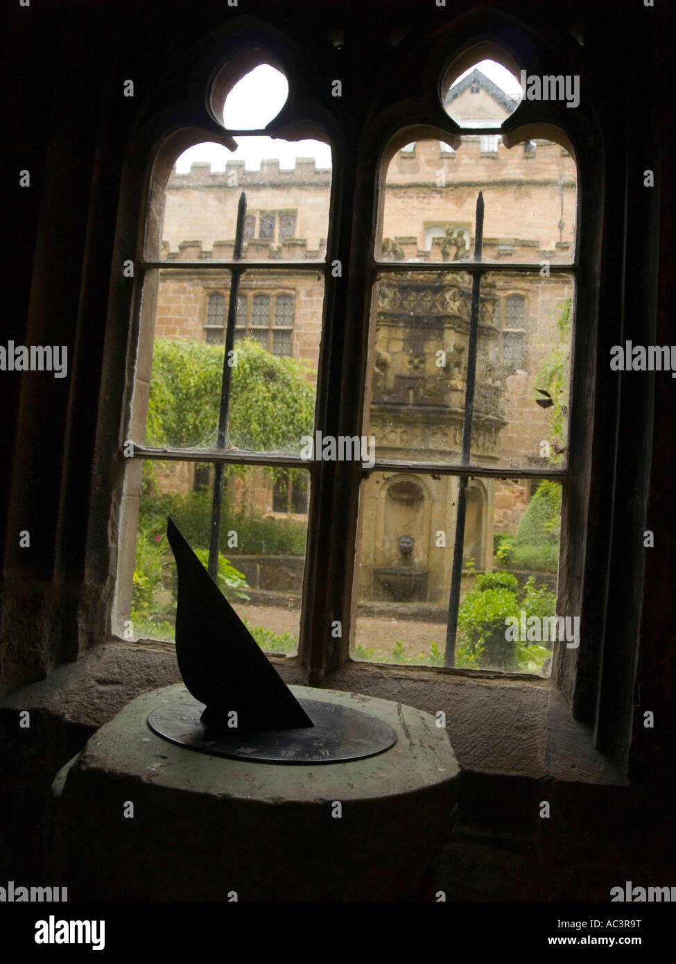 A sundial, and view through the window into a courtyard at Newstead Abbey, Nottinghamshire Stock Photo