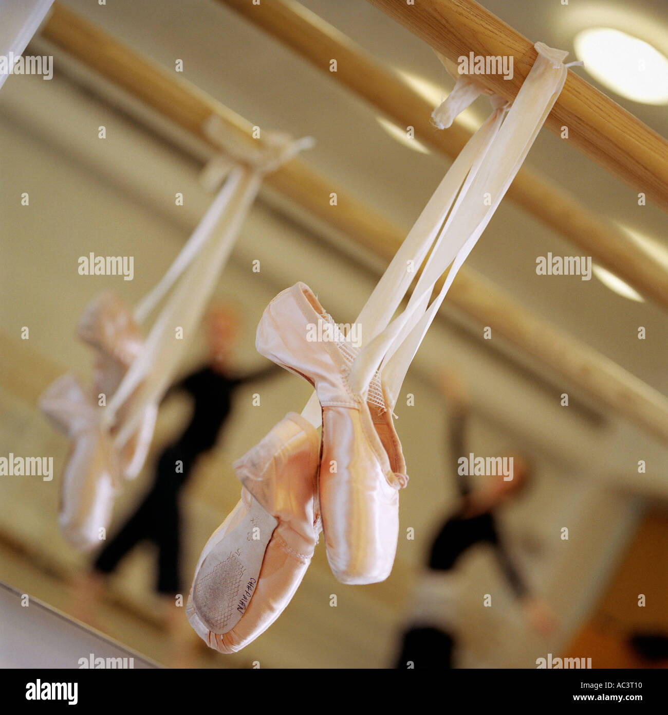 a pair of ballet shoes hanging with two ballerinas dancing in the
