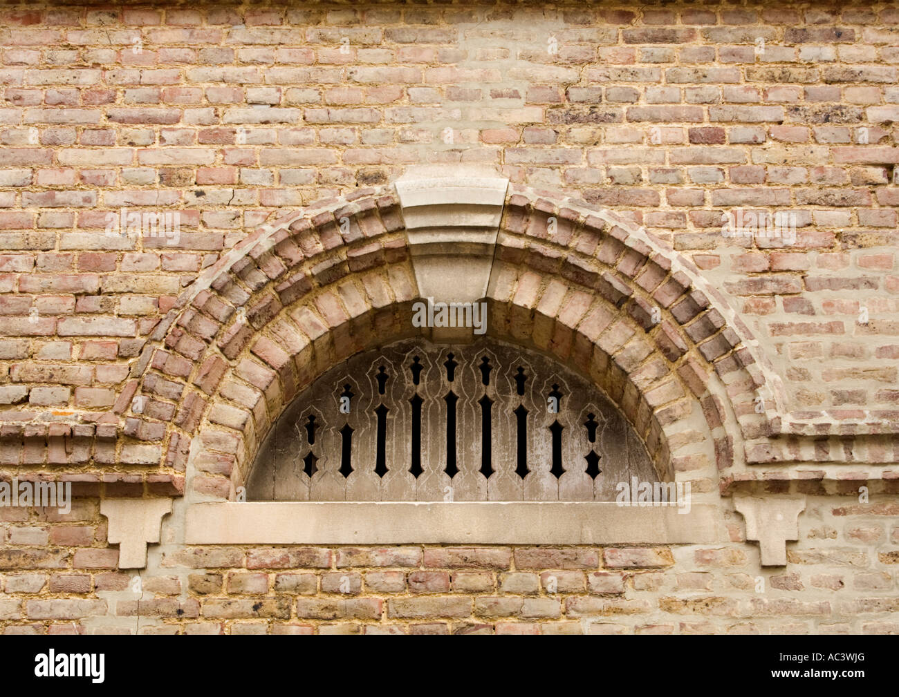 Romanesque arch in red brick with keystone and plate tracery Stock