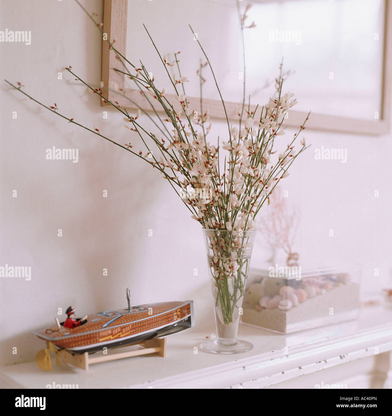 Flower arrangement on mantelpiece with toy boat Stock Photo