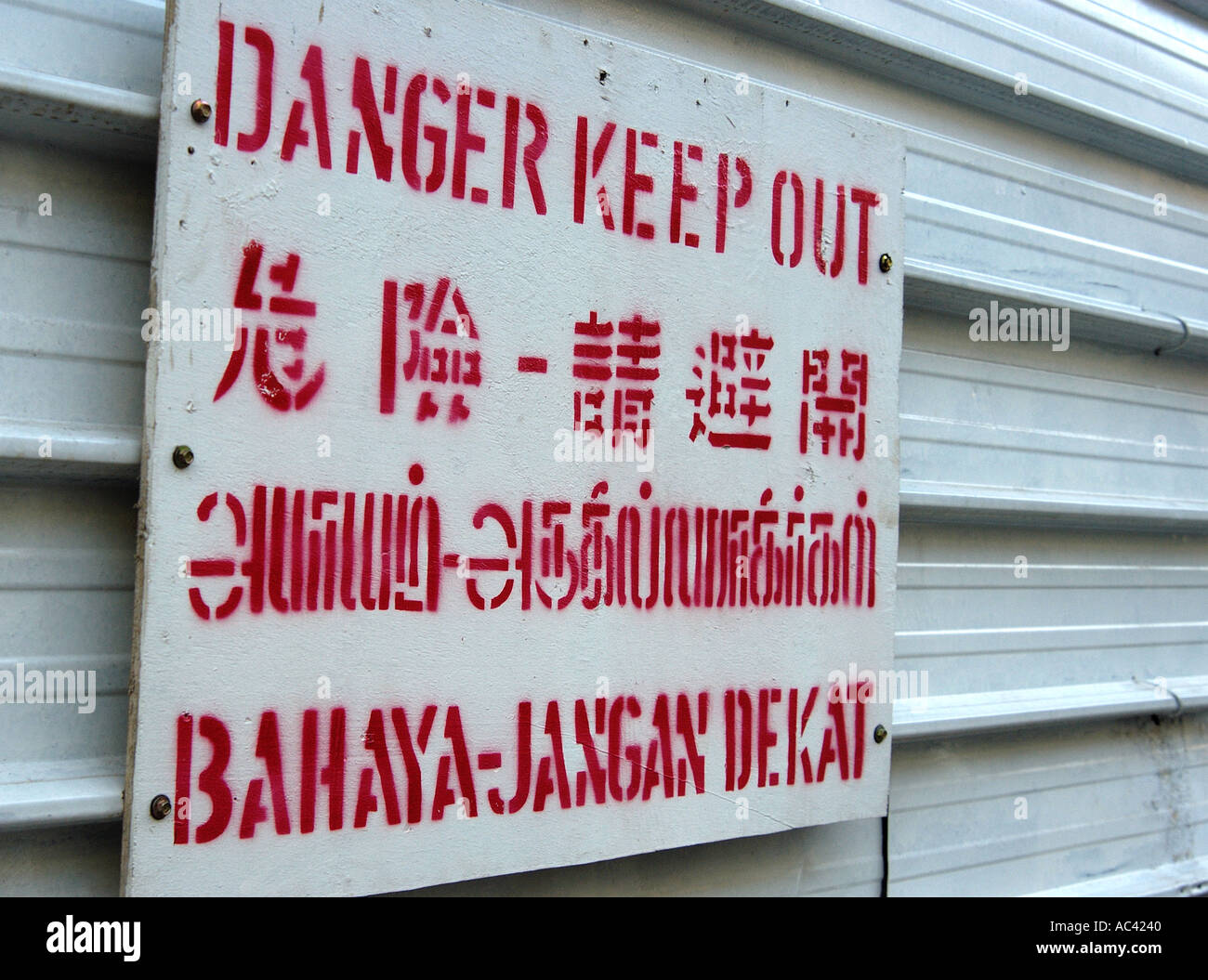 Danger Keep Out sign printed in English, Chinese, Thai and Indonesian. On a building site in Singapore. Stock Photo