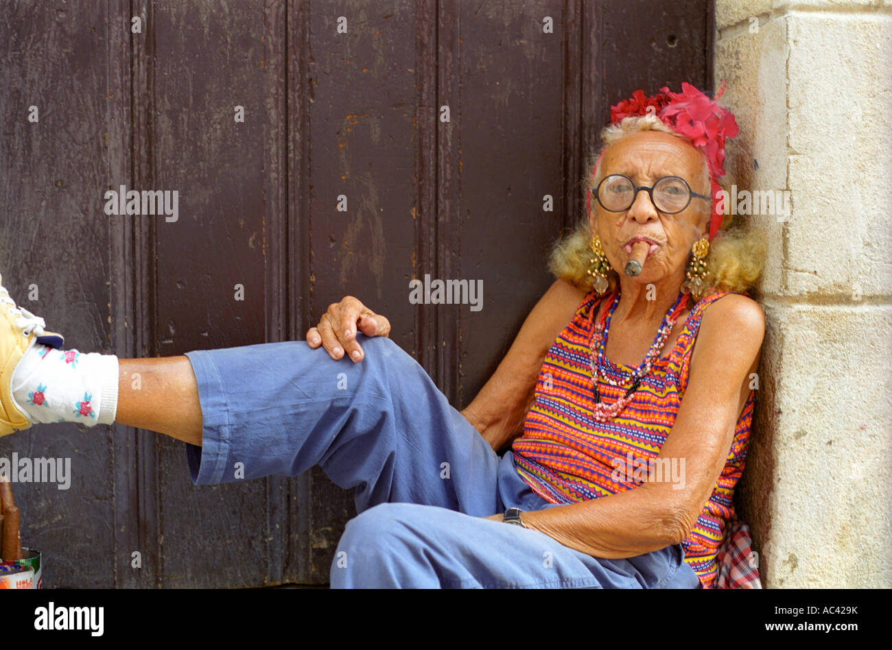 Old Cuban woman posing with cigar for tourists in Havana Stock Photo