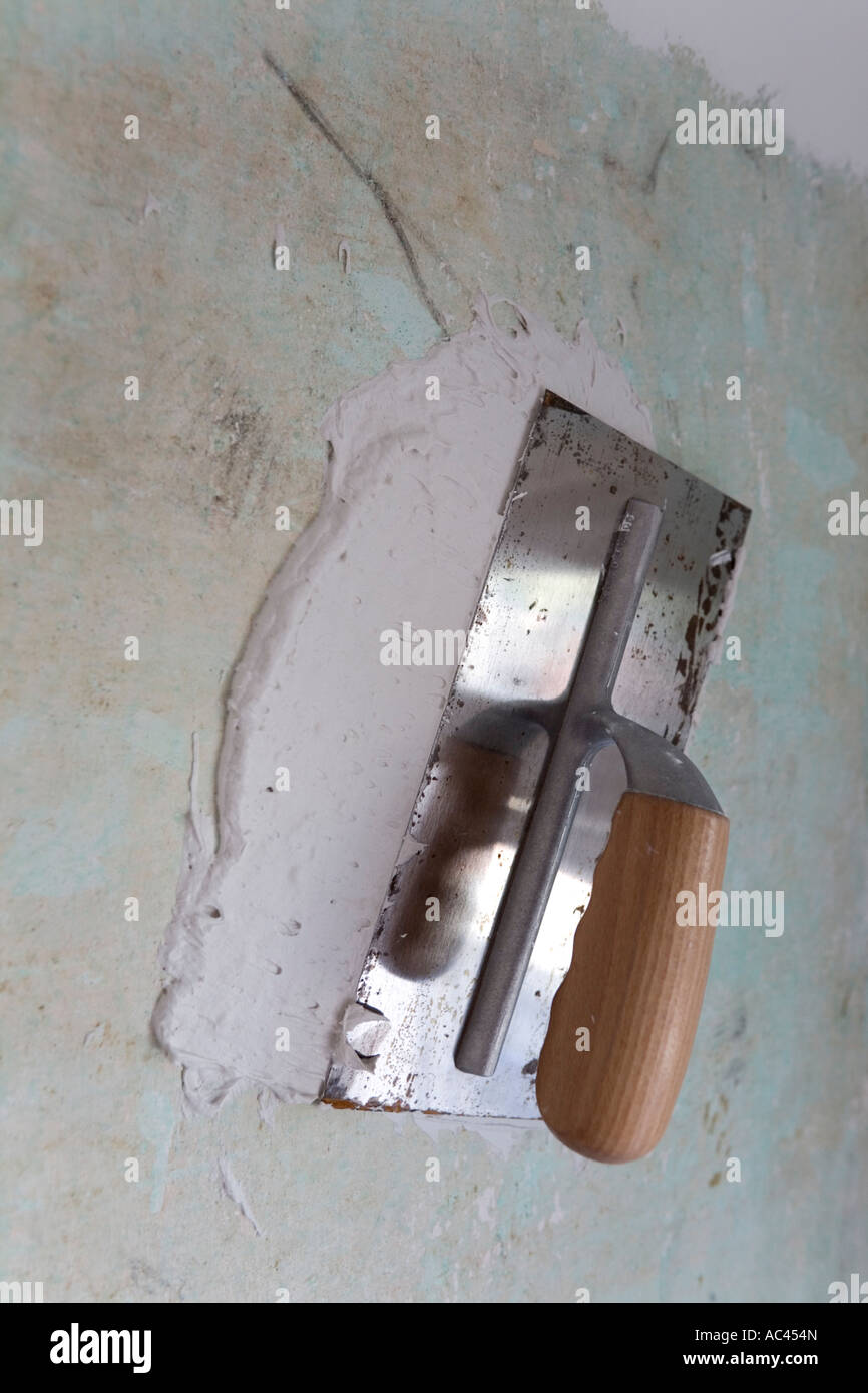 A Plasterer's float used for plastering an old wall. Platoir servant à enduire un vieux mur recouvert de plâtre. Stock Photo