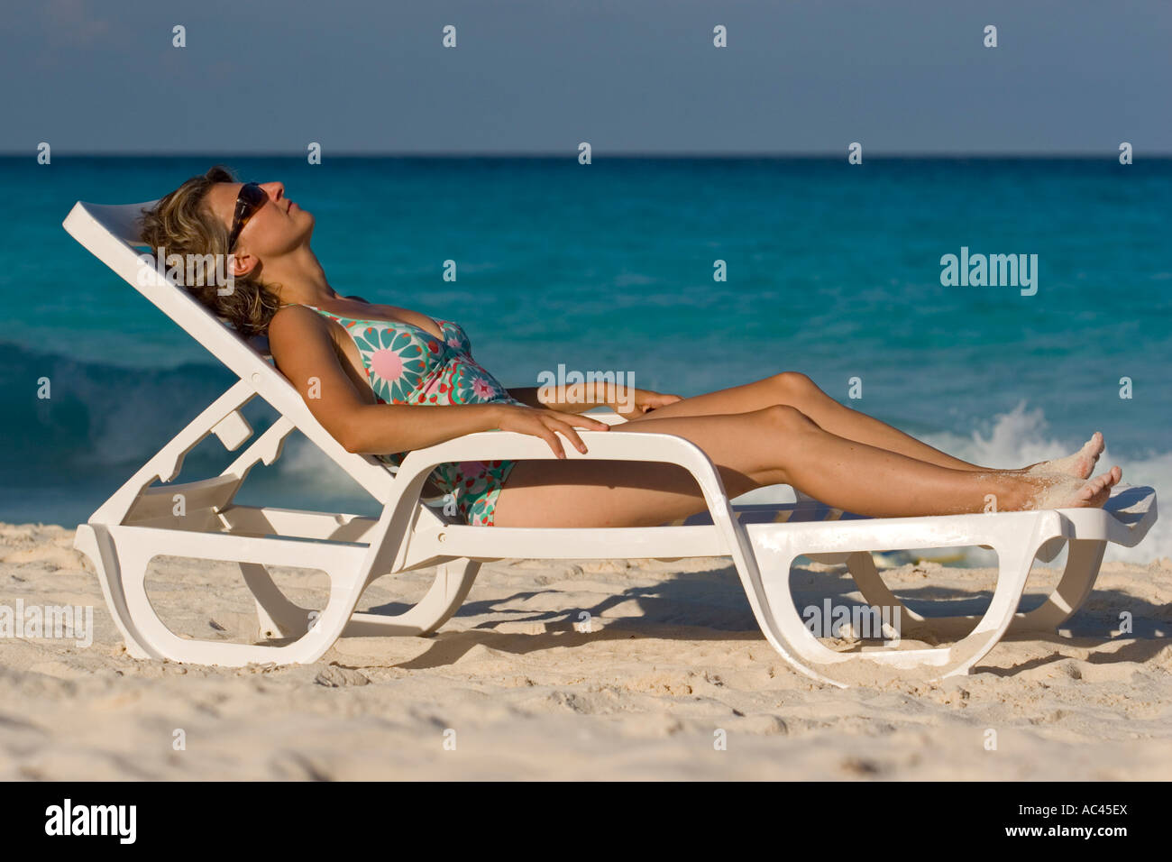 A young Lady sunbathing on a Cancún beach (Mexico). Jeune femme prenant un bain de soleil sur la plage de Cancún (Mexique). Stock Photo