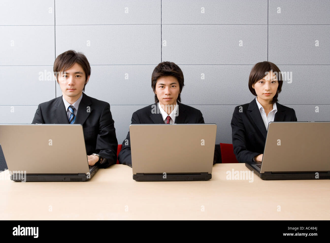 Three young business people using computers Stock Photo - Alamy