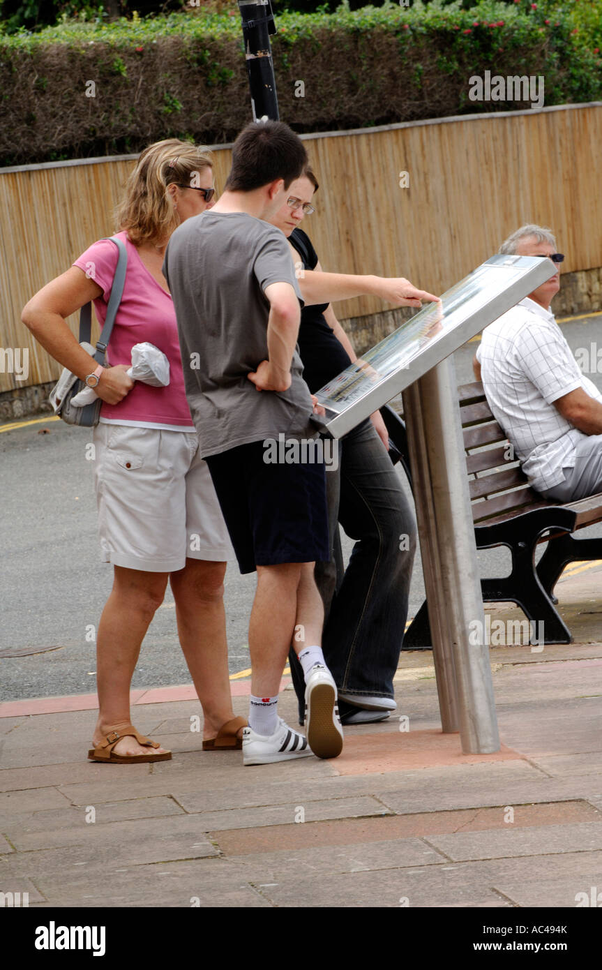 people tourists holiday makers looking at town guide map for information at cowes on the isle of wight Stock Photo