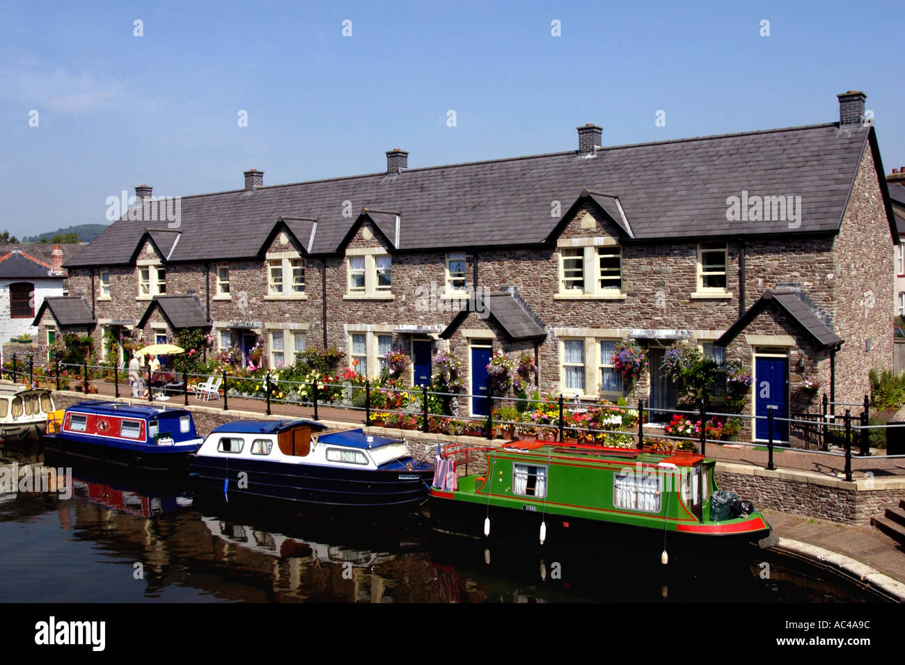 Narrowboats Moored Next To Canalside Cottages On The Monmouthshire