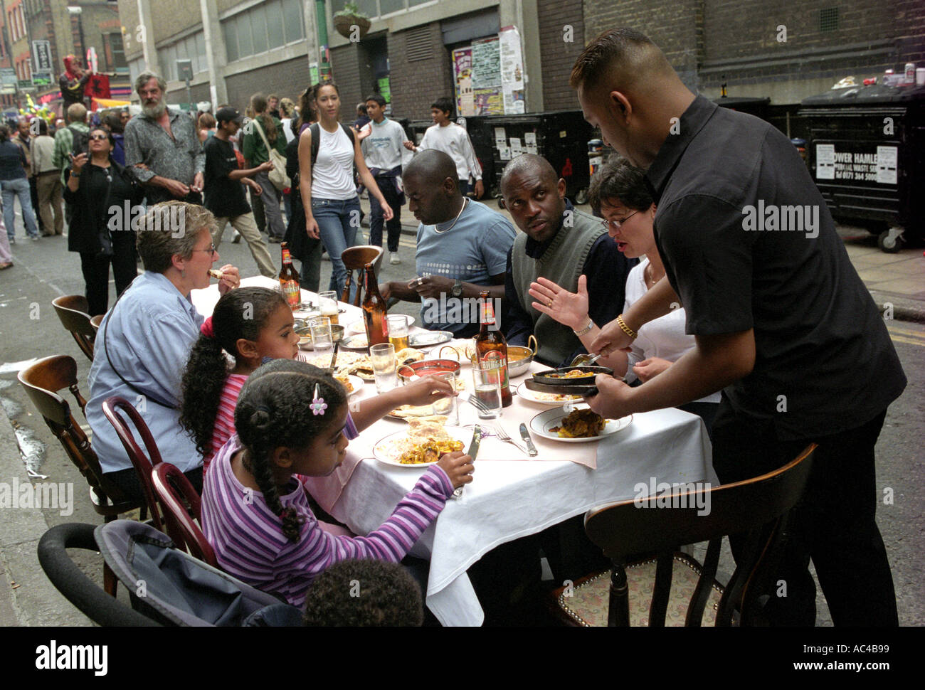 Family having a meal in Brick Lane London during the Bangladesh summer festival. Stock Photo