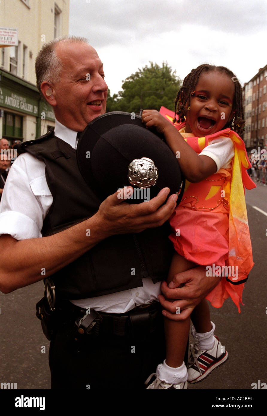 A police officer carrying  a small girl at the notting Hill carnival in London. Stock Photo