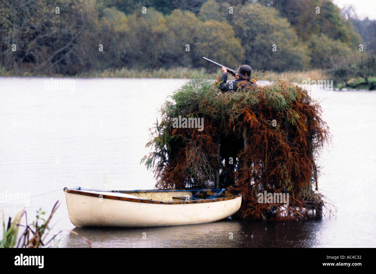 A shooter in a hide at a duck shoot on a lake in Ireland Stock Photo