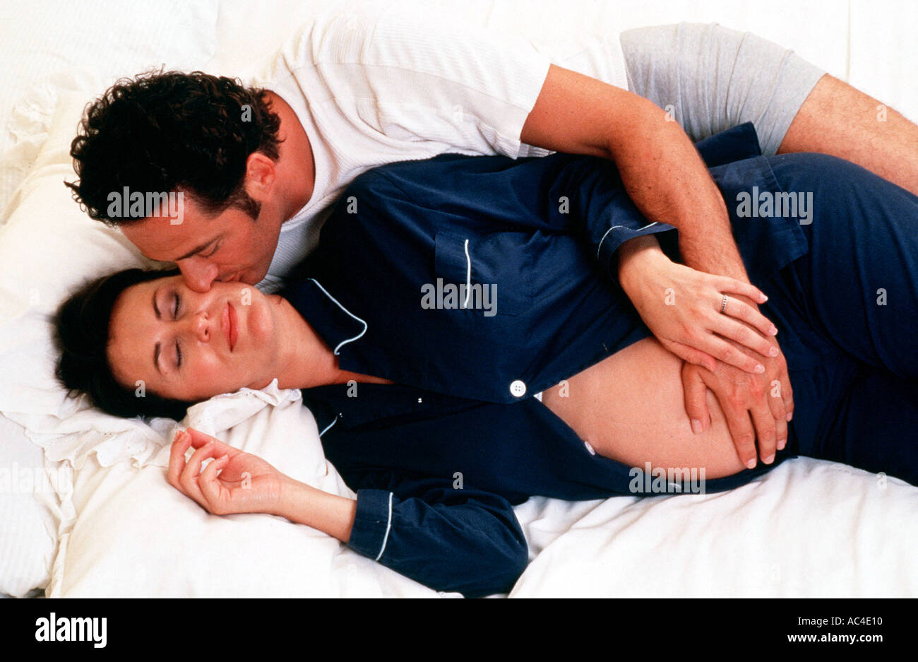 W 18126 02 Model Released Pregnant couple lying in bed Henry Arden RBO Stock Photo