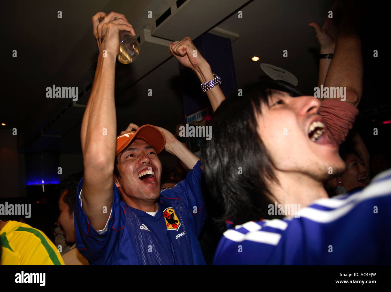 Japanese fans celebrate their goal in 1-4 defeat vs Brazil, 2006 World Cup Finals, Moon Under Water bar, London Stock Photo