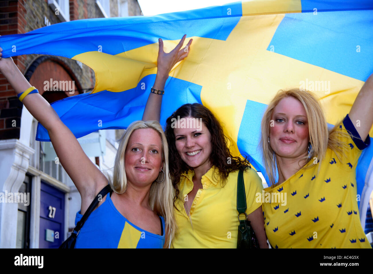 Swedish fans waving national flag prior to 2006 World Cup Finals game vs Germany, Harcourt Arms, London Stock Photo