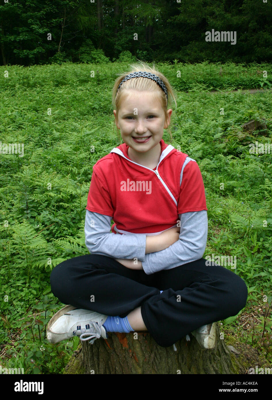 Young girl sitting cross legged Stock Photo