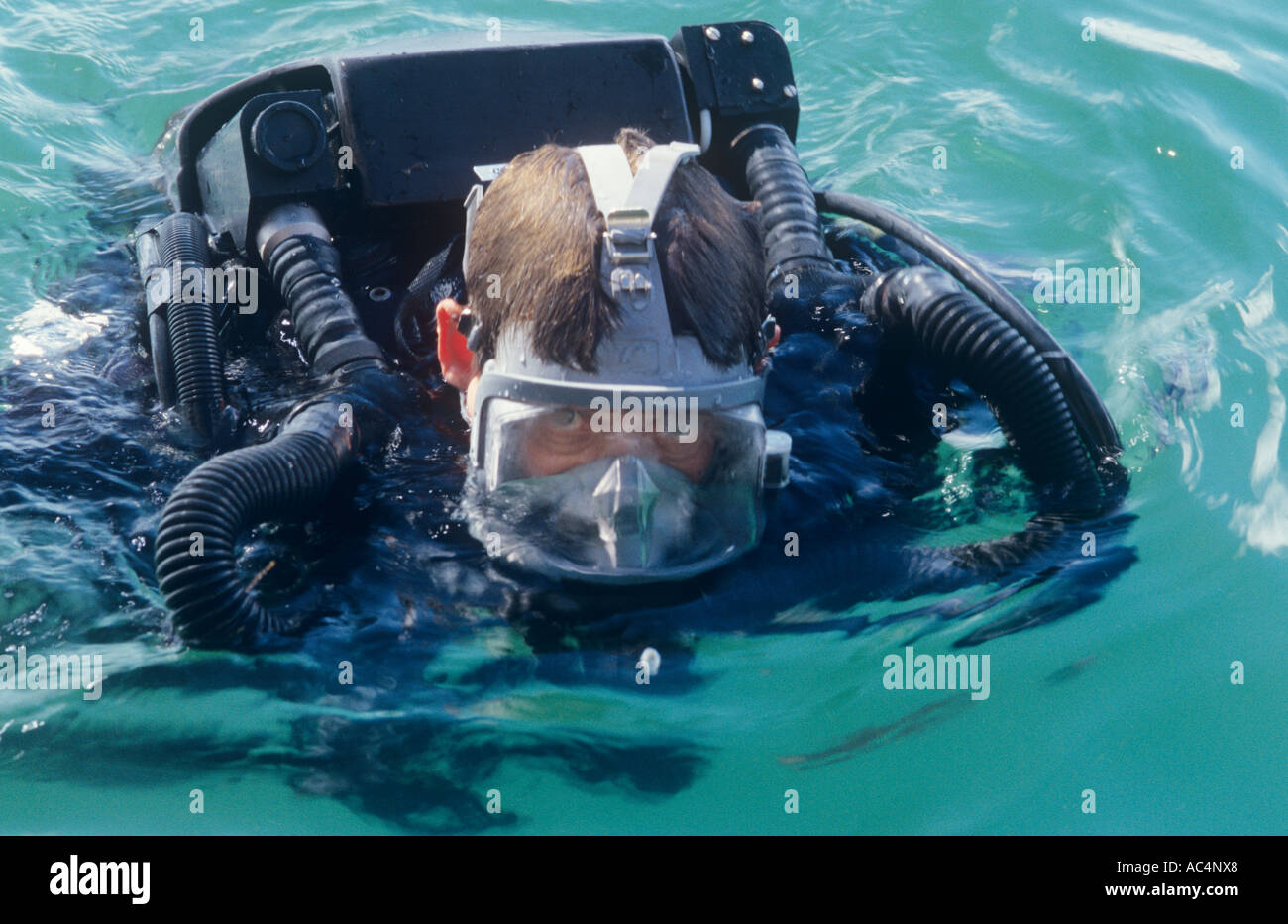 Military EOD diver wearing full face mask with built in communications and using a rebreather Stock Photo
