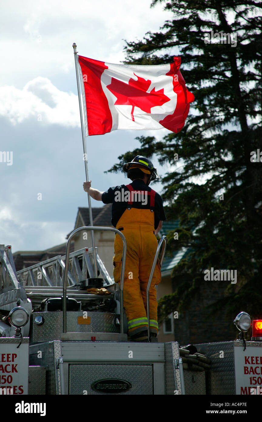 Fireman holding Canadian national flag Canada Day celebrations Banff