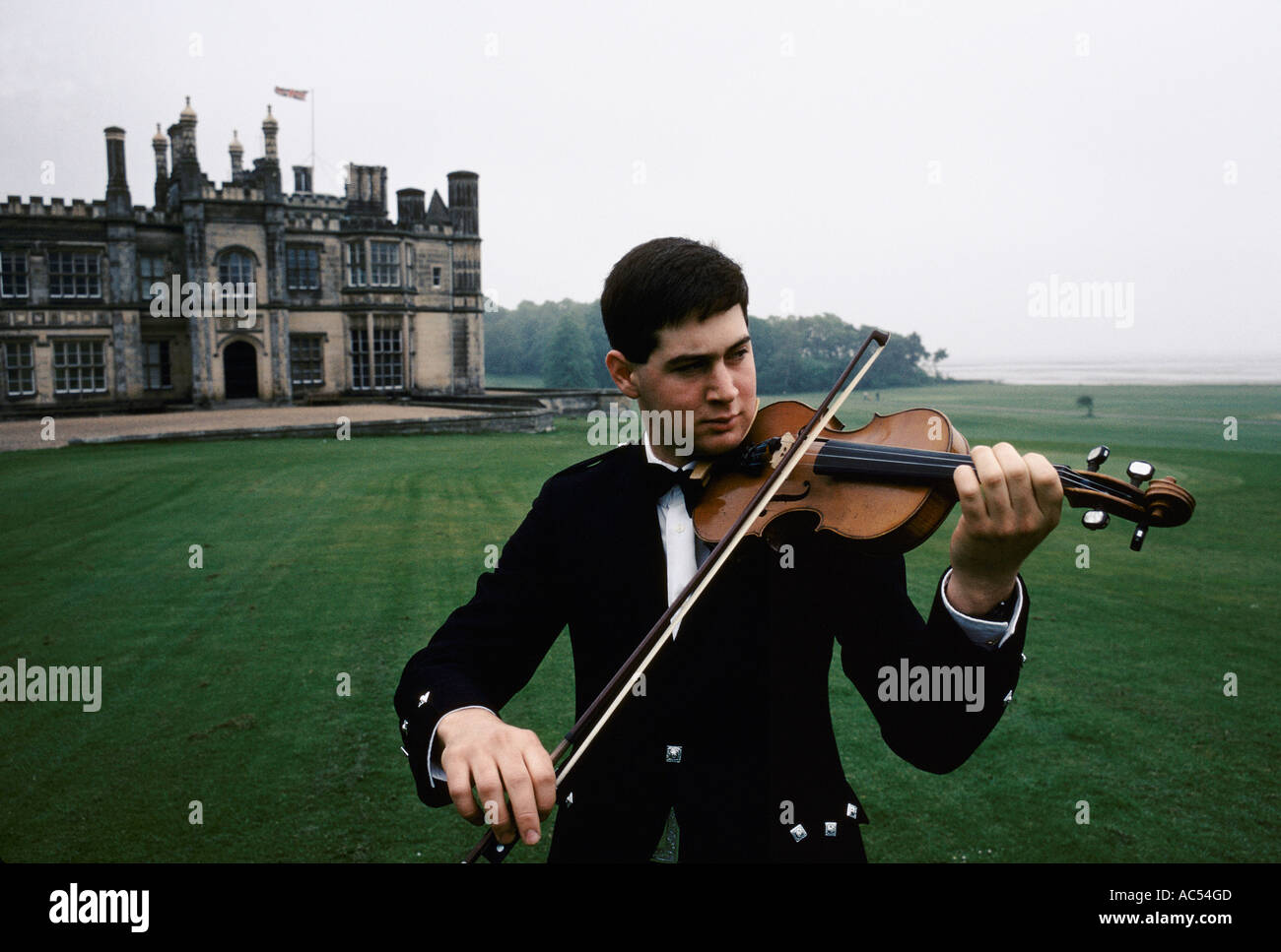 DALMENY HOUSE SCOTLAND MARTIN DUNCAN THE PIPER PLAYING VIOLIN OUTSIDE IN FRONT OF THE HOUSE JULY 1992 Stock Photo