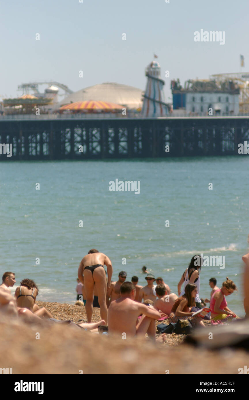 man in thong exposing buttocks on Brighton beach Stock Photo image