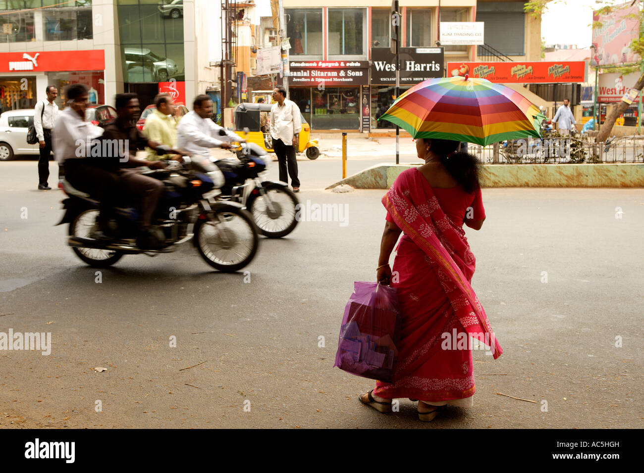 Woman Crossing the road with rainbow umbrella parasol Chennai Madras