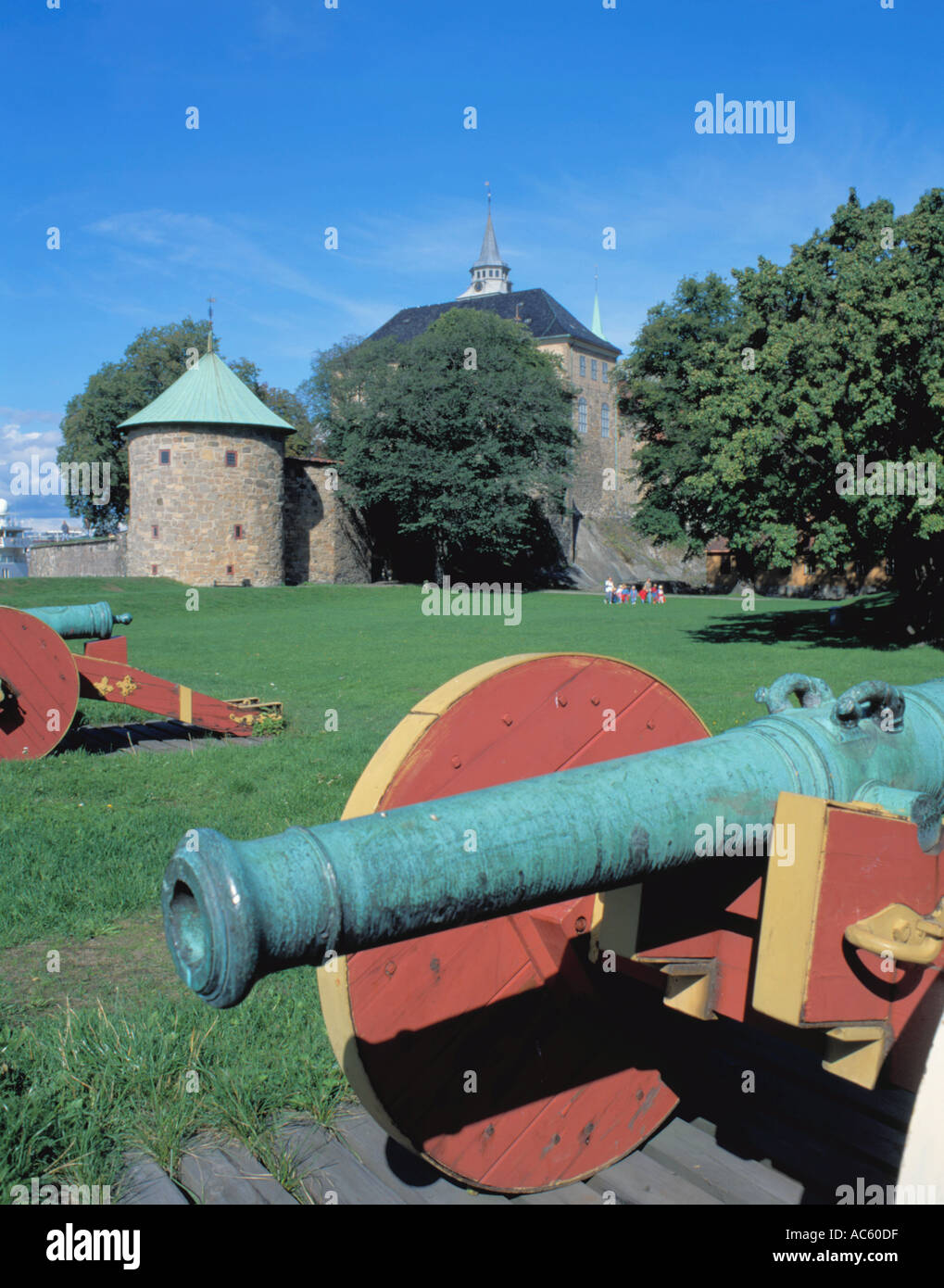 Old green bronze cannon with circular stone "drum tower" beyond, Akershus Festning (Fortress), Oslo, Norway. Stock Photo