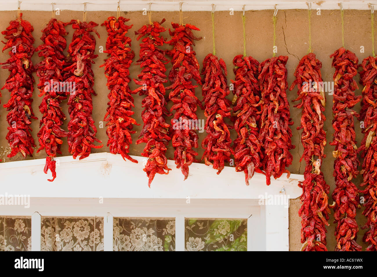RED CHILE PEPPERS HANGING ON STORE FRONT CHIMAYO, NEW MEXICO Stock