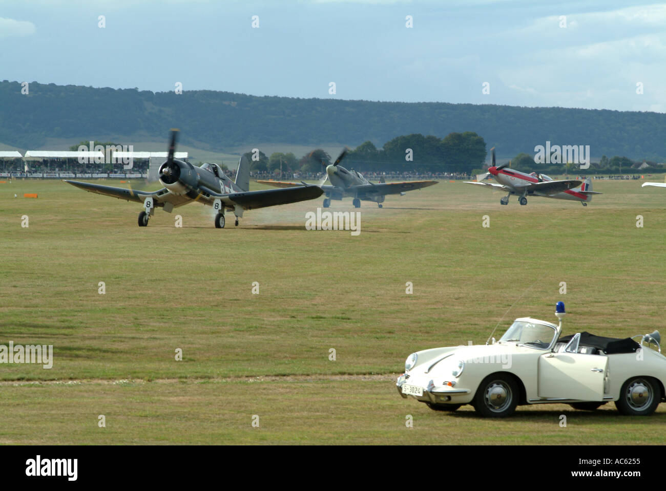 Corsair FG 1D Chance Vought and Two Spitfires Preparing for Take Off with Porsche Course Car at Goodwood Revival 2003 Sussex Stock Photo