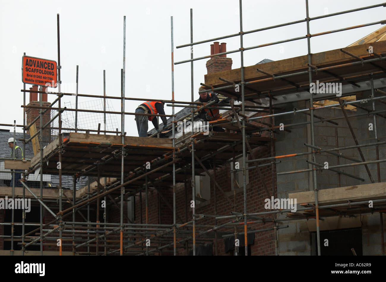 Construction workers tiling a roof on a block of flats in Filey North