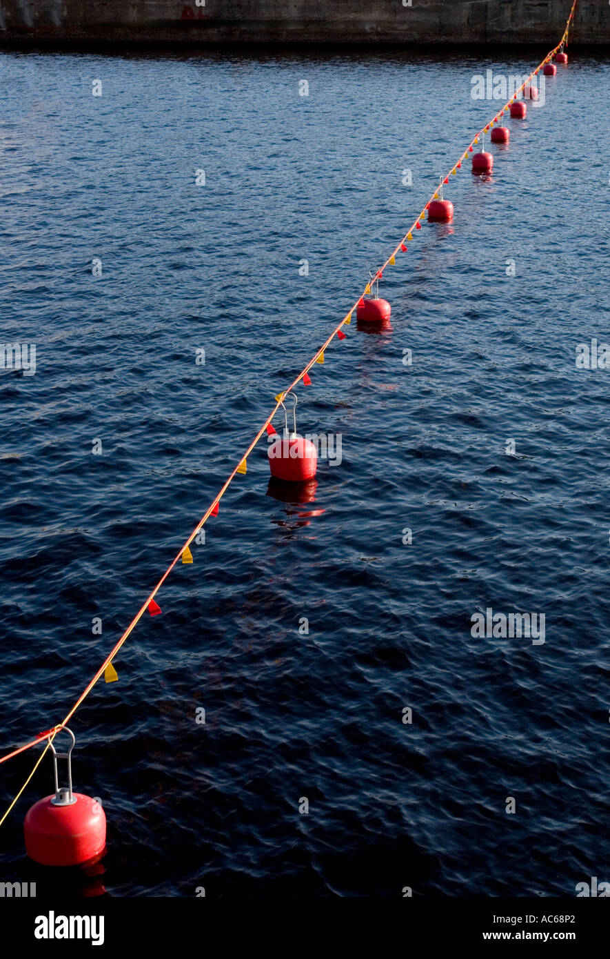 Red floating buoys connected to each other with rope hi-res stock ...