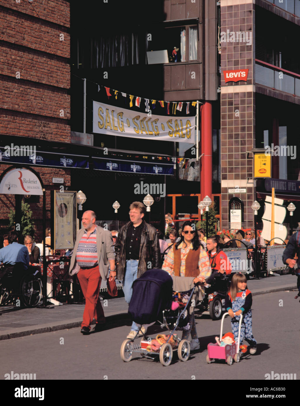 Mother and daughter both pushing a pram; on Aker Brygge, central Oslo, Norway. Stock Photo