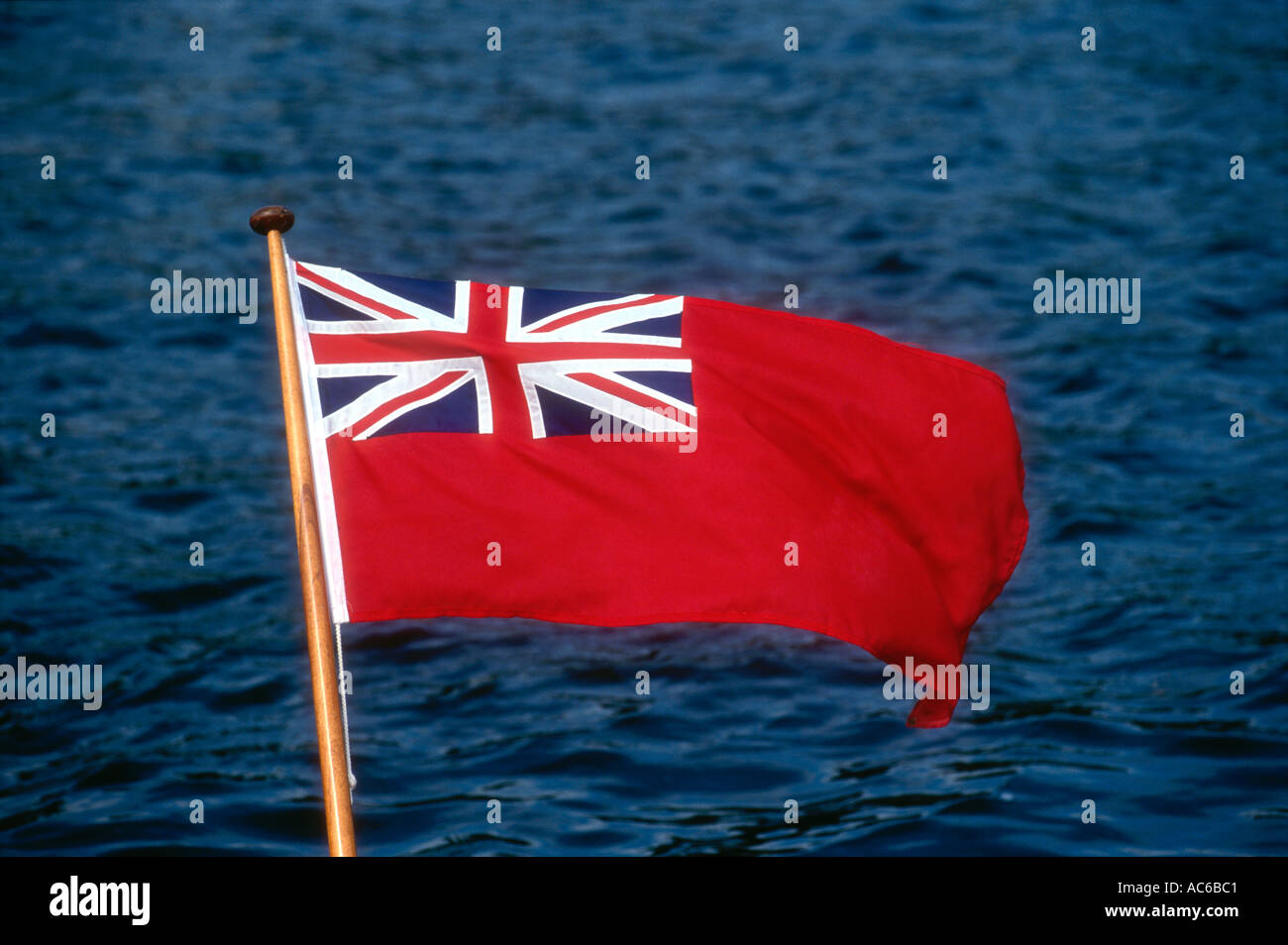 The Red Ensign flies at the stern ofg a pleasure launch on the River Thames at Henley in Oxfordshire England UK Stock Photo