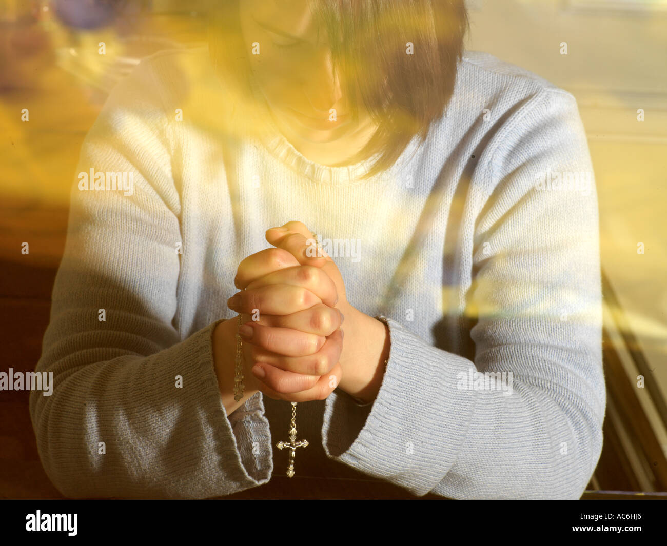 Woman Praying with a Rosary Stock Photo