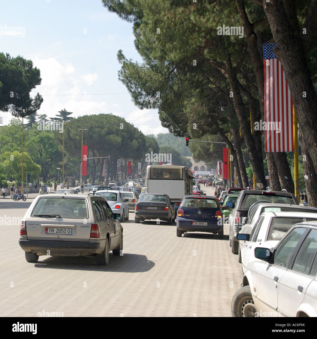 Traffic & street scene in Tirana Republic of Albania main road from Skanderbeg Square USA banner flags  for America state visit by American President Stock Photo